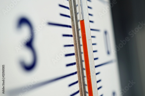 Macro detail of and old dusty outdoor thermometer in the retro design measuring very high temperature of thirty five degrees of Celsius as a symbol of summer and heat  photo