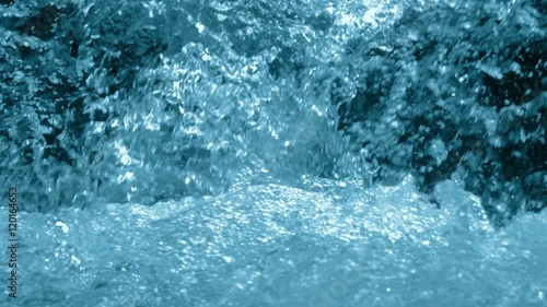 Water rages in the flow of the waterfall. Close-up. Slow motion