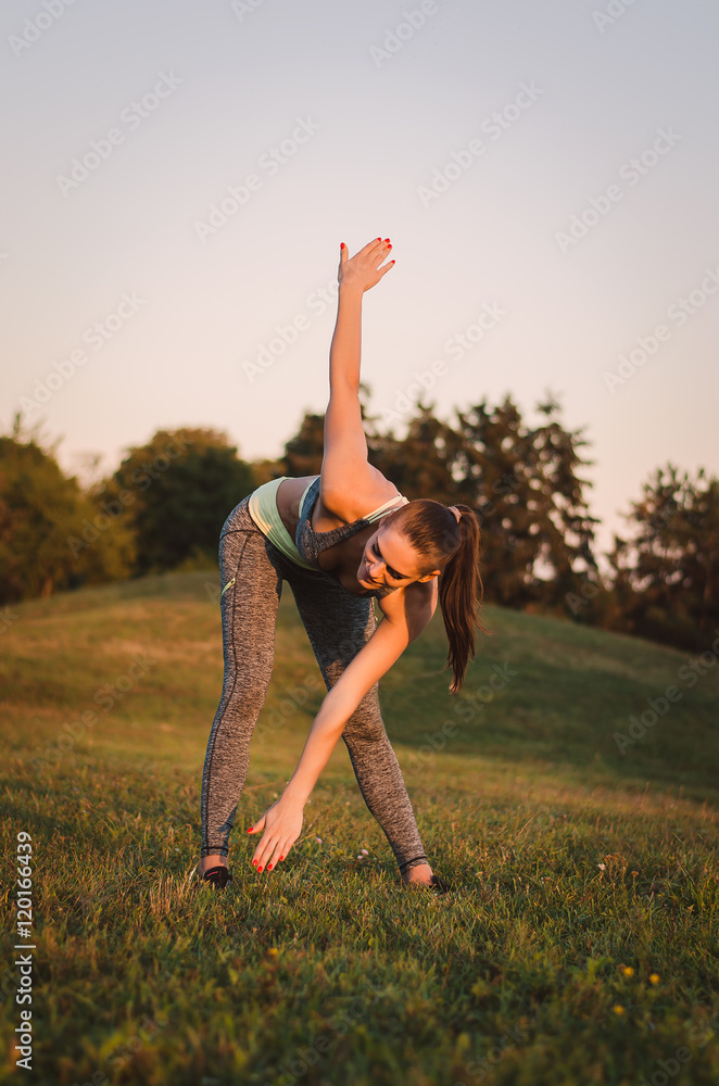attractive young fitness woman training in the park. She makes a attractive young fitness woman training in the park. She makes a