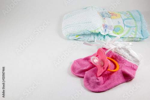 Pacifier, booties, baby diaper on a white background