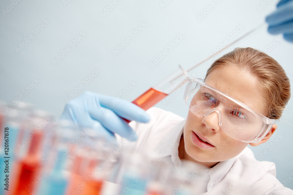 Woman chemist taking sample of chemical liquid with pipette Woman chemist taking sample of chemical liquid with pipette