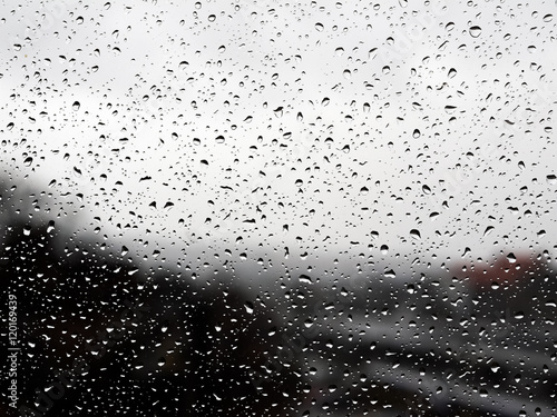 Raindrops on a window before an blurry background