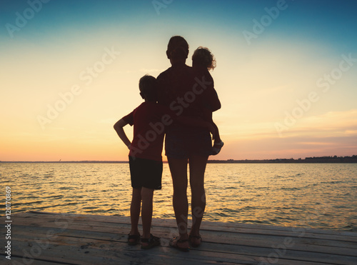 Silhouette of family watching sea sunset