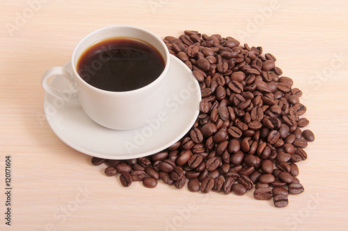 Coffee beans and a white cup on table
