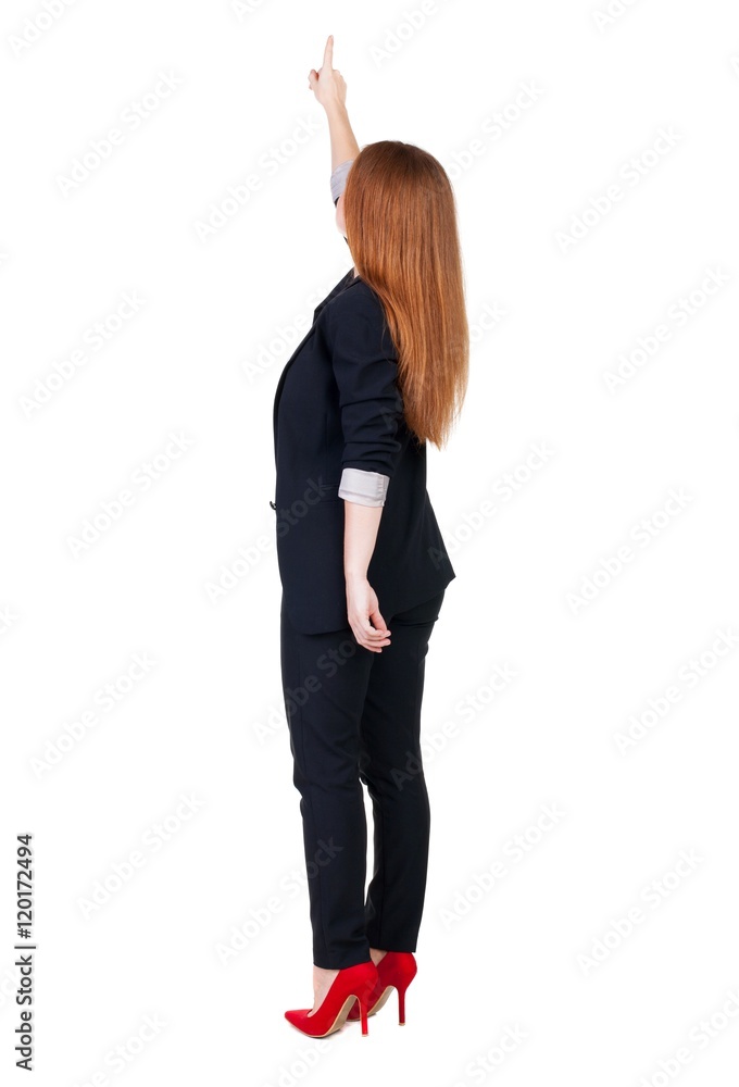 Back view of young redhead business woman pointing at wall. beautiful girl in dark suit. Rear view people collection. backside view of person. Isolated over white background. Back view of young redhead business woman pointing at wall. beautiful girl in dark suit. Rear view people collection. backside view of person. Isolated over white background.