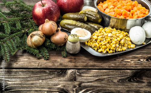 Vegetables for christmas salad on wooden table.