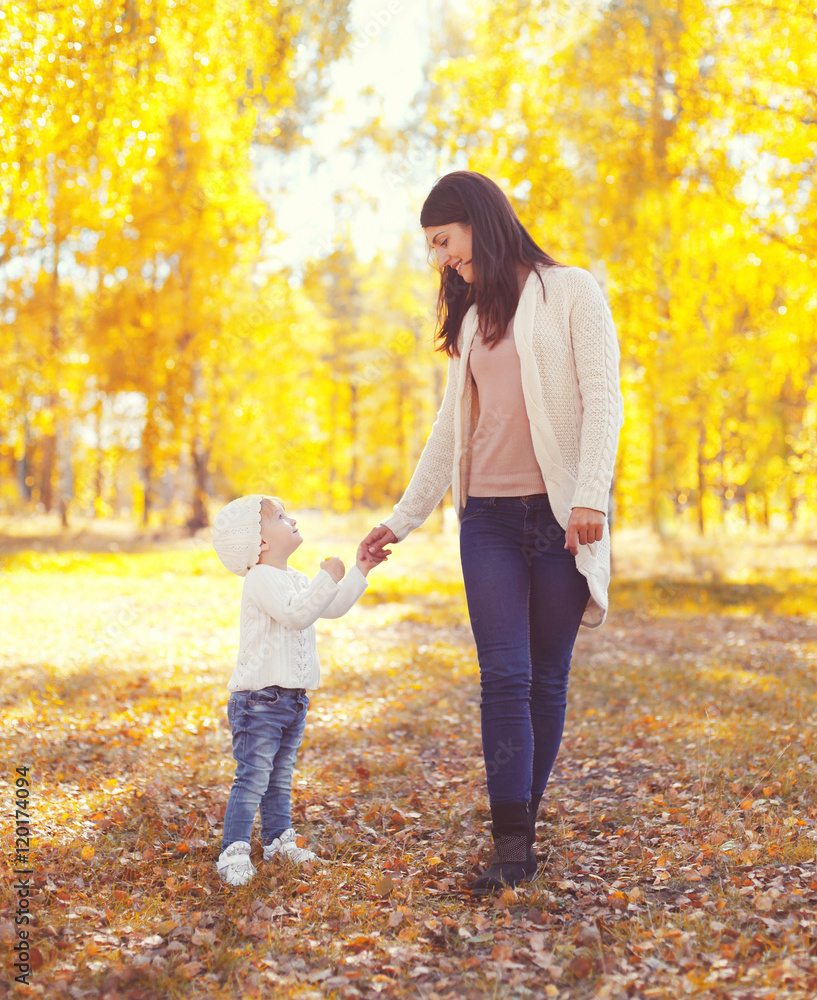 Happy smiling mother walking with child in warm sunny autumn day Happy smiling mother walking with child in warm sunny autumn day