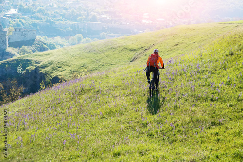 Young man traveler riding on bicycle with red backpack