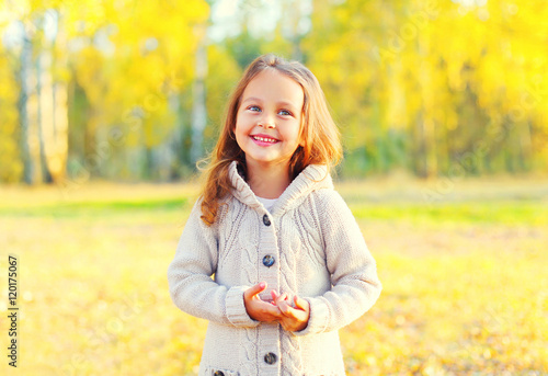 Portrait happy smiling child having fun in sunny autumn day