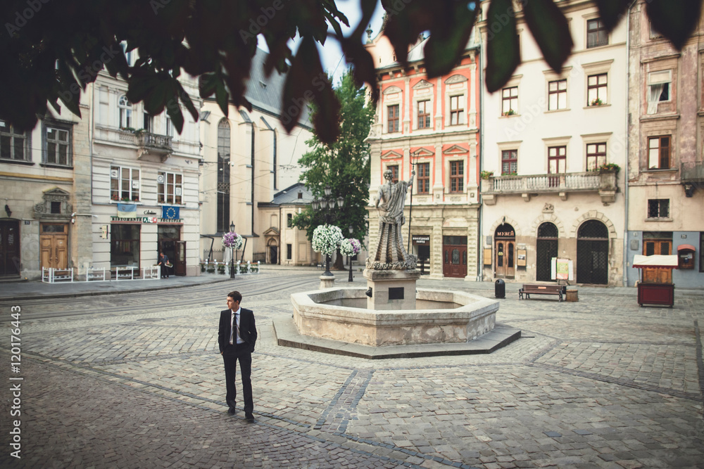 a young man stands in the city center