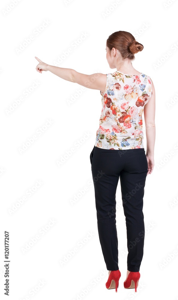 Back view of young redhead business woman pointing at wall. beautiful girl in dark suit. Rear view people collection. backside view of person. Isolated over white background. Back view of young redhead business woman pointing at wall. beautiful girl in dark suit. Rear view people collection. backside view of person. Isolated over white background.