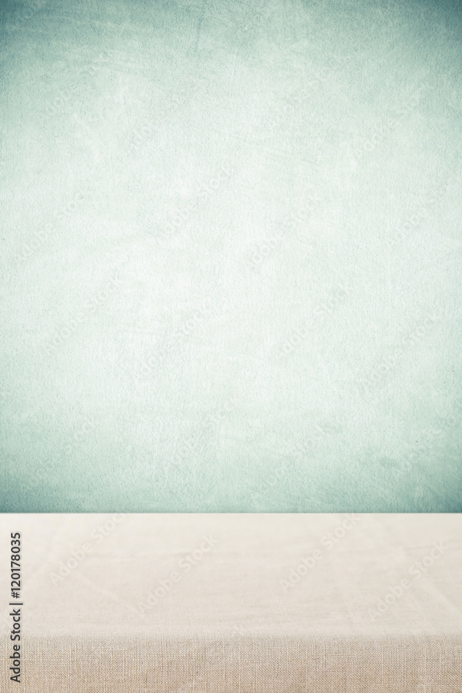 Empty table with linen tablecloth over cement wall background Empty table with linen tablecloth over cement wall background