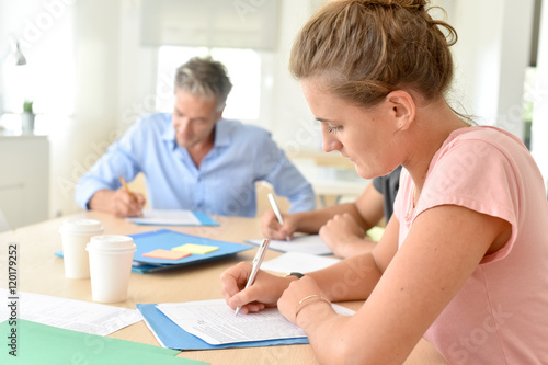 College students filling in registration forms