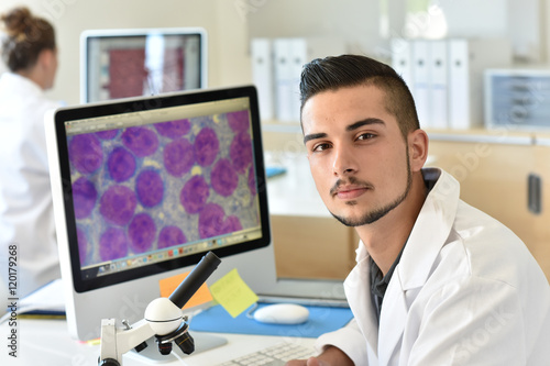 Student in biology using microscope in training class