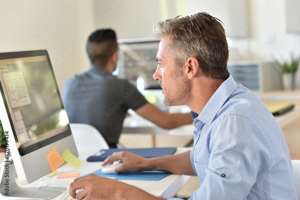 Businessman working in office in front of desktop Businessman working in office in front of desktop