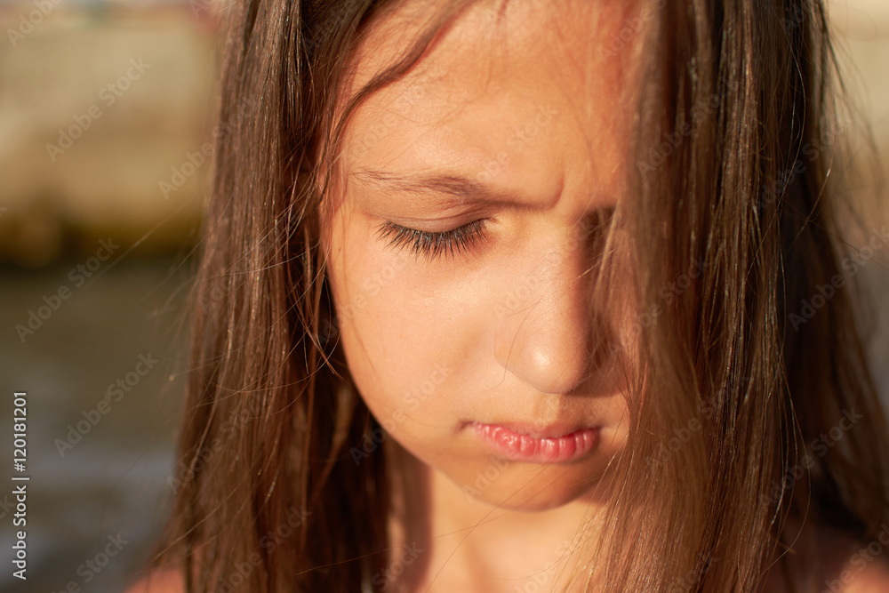 portrait of a little sad girl on the shore