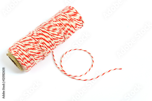 Roll of red and white rope on white background