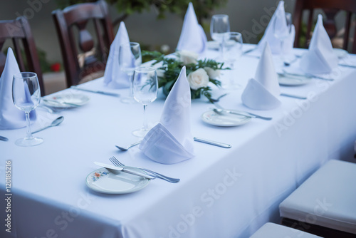 Festively laid table with white tablecloths glasses and plates