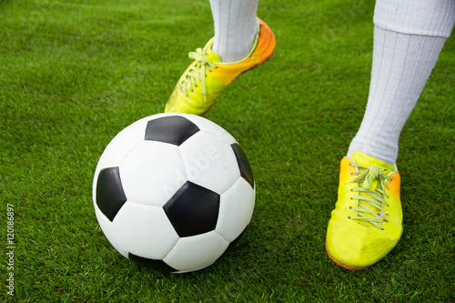 Leg person kick soccer ball on grass