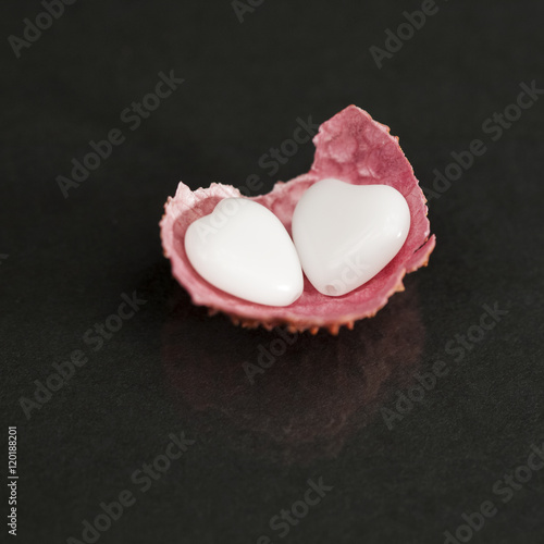 Litchi peel with heart shaped agate on black background
