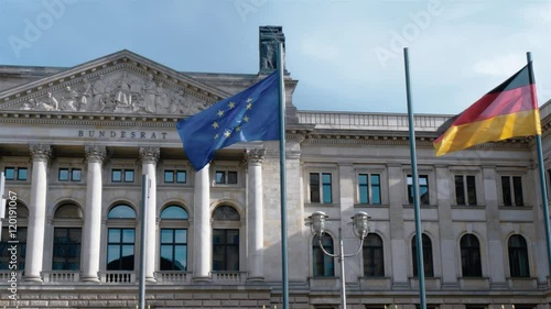 Real time locked down shot of Bundesrat building front facade in Berlin, Germany.  German flag and the flag of European Union are waving on the wind. photo