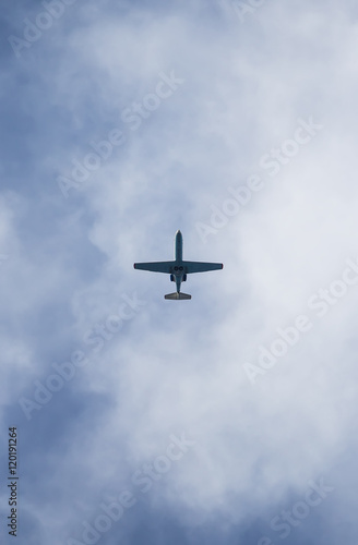 A plane flying in the blue sky with white clouds