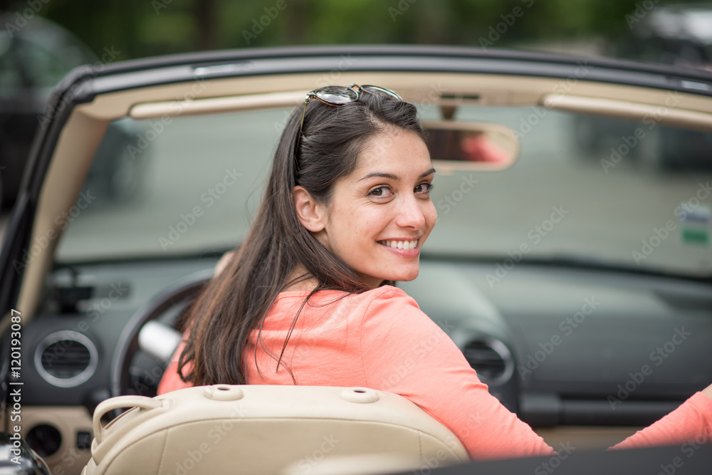  A beautiful young woman driving her convertible car