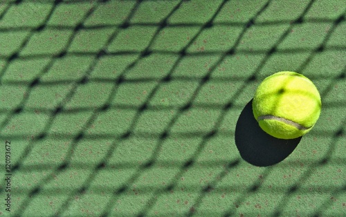 tennis ball in net shadow © driftwood