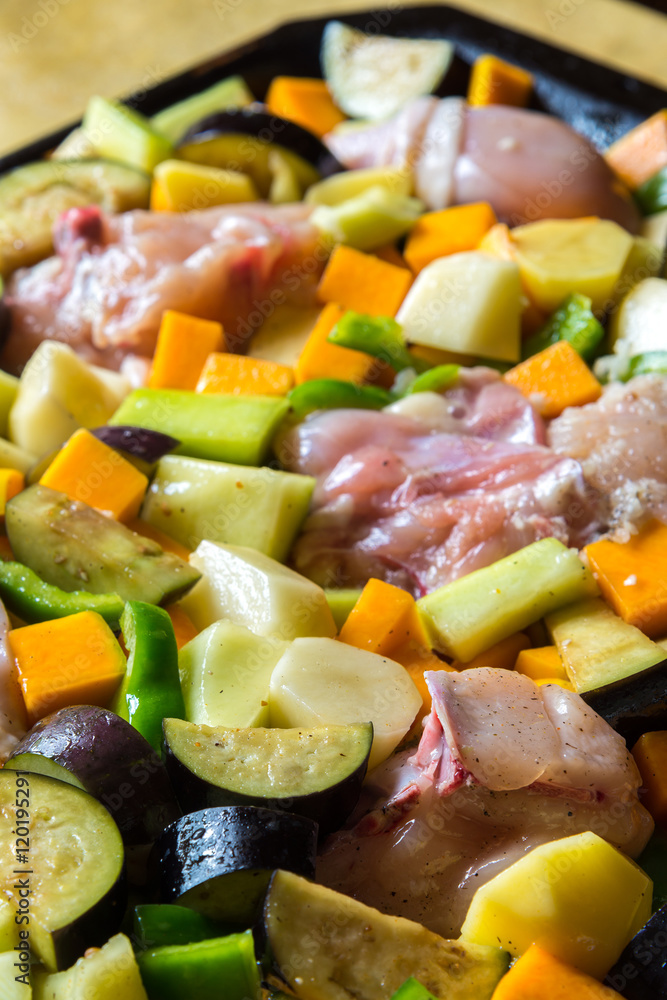 raw chicken with vegetables in pan raw chicken with vegetables in pan