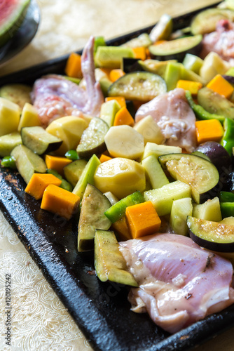 raw chicken with vegetables in pan
