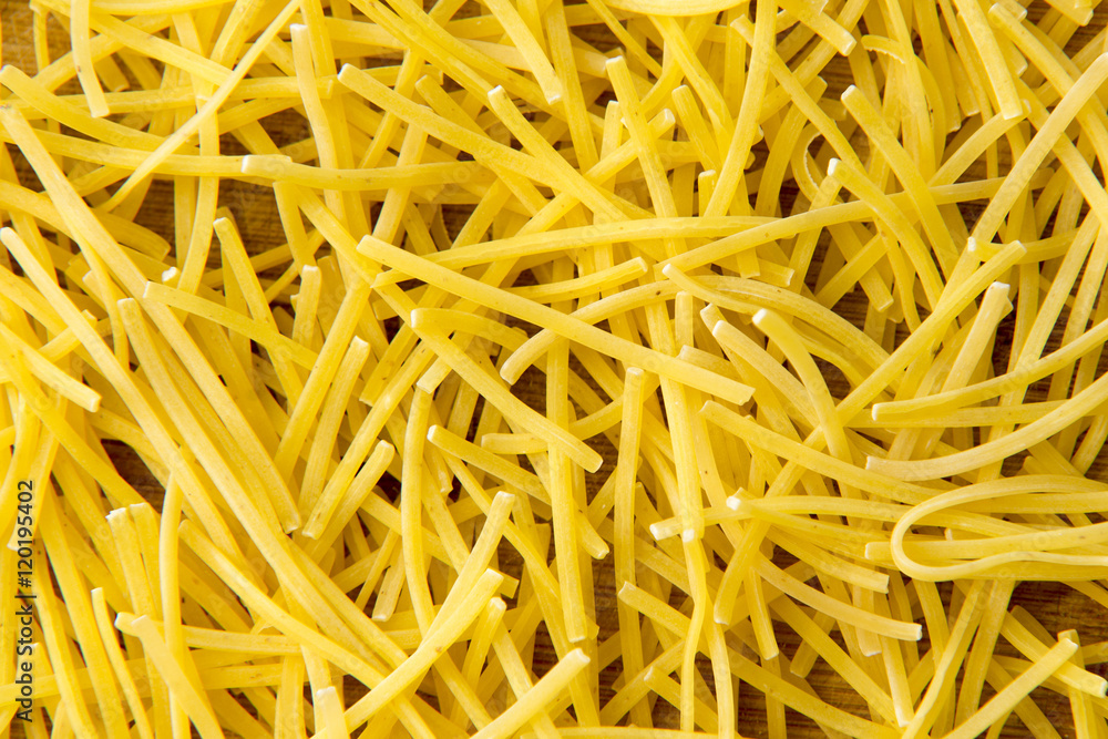 Small dry pasta noodles on wood background or texture Small dry pasta noodles on wood background or texture