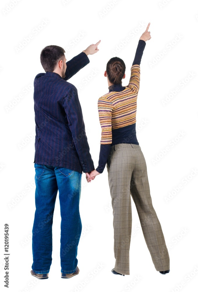 Young couple pointing at wall. Rear view. Isolated over white background. Young couple pointing at wall. Rear view. Isolated over white background.