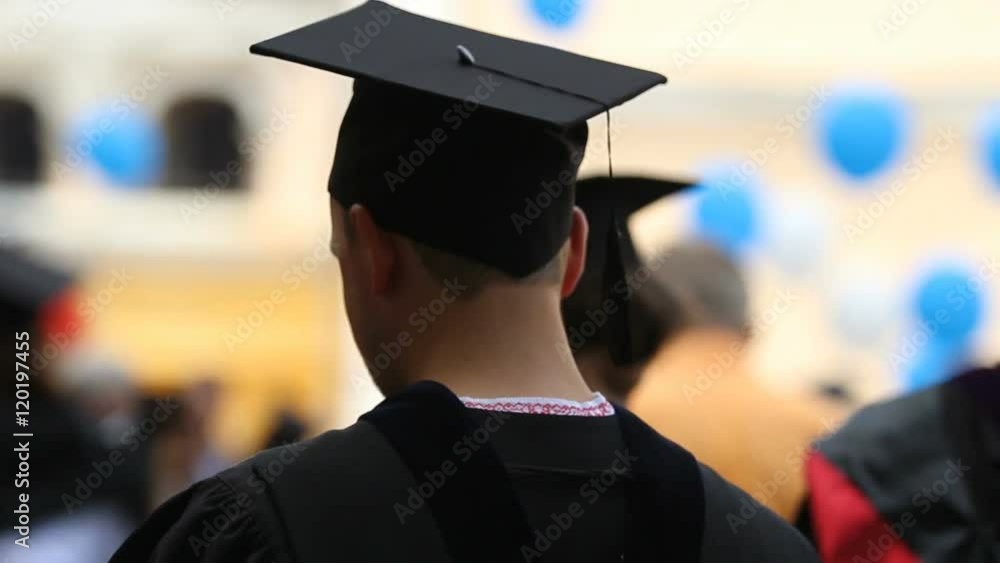 Male university graduate waiting to receive higher education diploma at ceremony Male university graduate waiting to receive higher education diploma at ceremony
