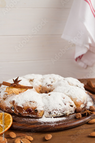 Christmas stollen and spices on wooden background