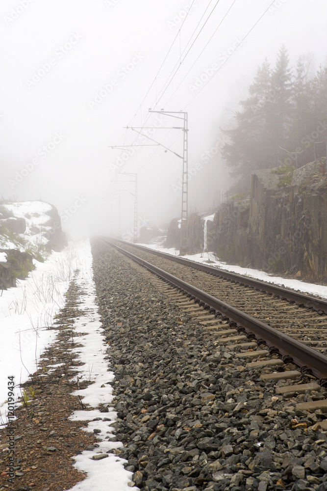 Life is a journey as a thought. Image of an empty railroad taken from low point of view. A thick fog is filling the atmosphere