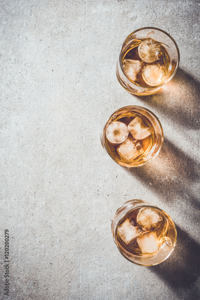 Glasses of whiskey on gray stone table Glasses of whiskey on gray stone table