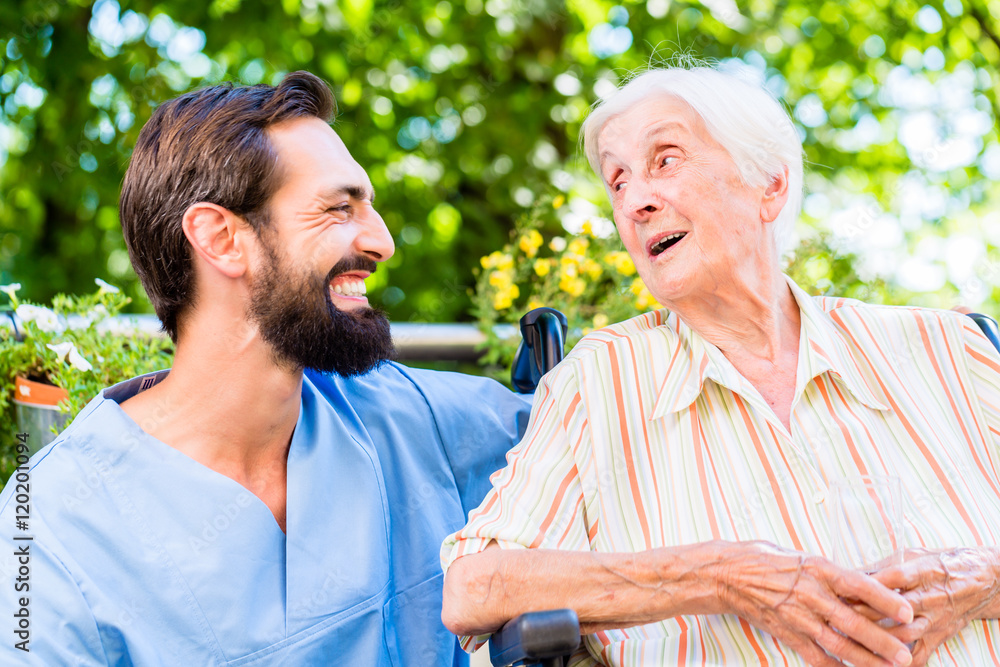 Fotografie Nurse having chat with senior woman in nursing home