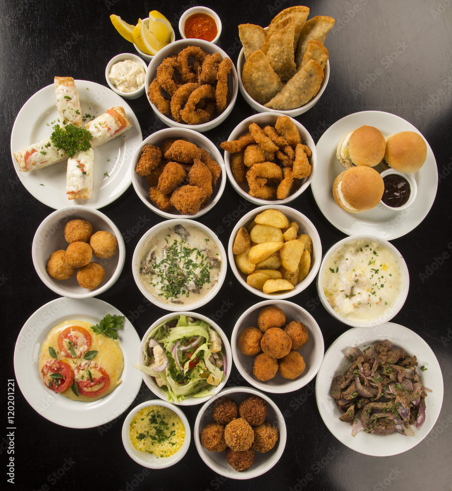Mixed brazilian snacks, including pastries, fried chicken, salad Mixed brazilian snacks, including pastries, fried chicken, salad