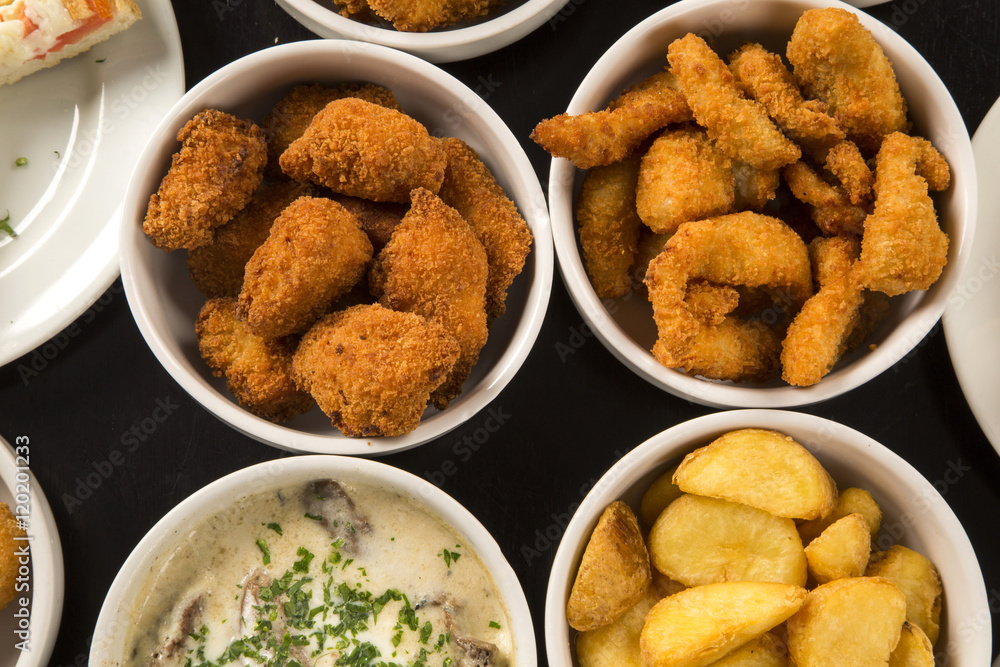 Mixed brazilian snacks, including pastries, fried chicken, salad Mixed brazilian snacks, including pastries, fried chicken, salad