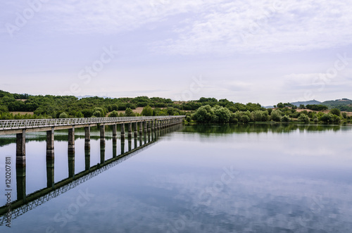 Puente sobre lago hacia el verde bosque © Josebatm