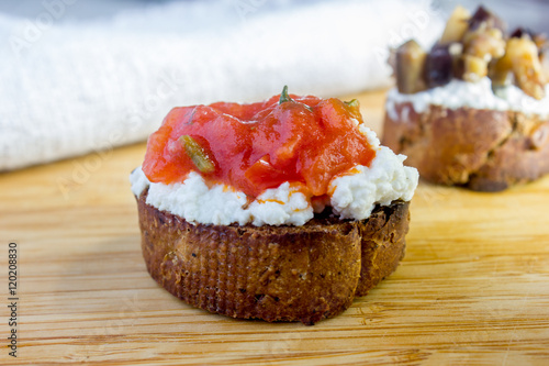 Bruschetta with ricotta cheese and tomato sauce on wooden background