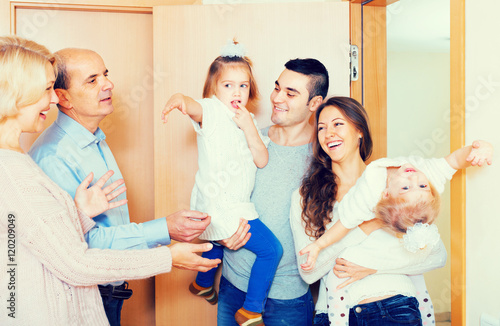 Aged couple meeting family at doorstep photo