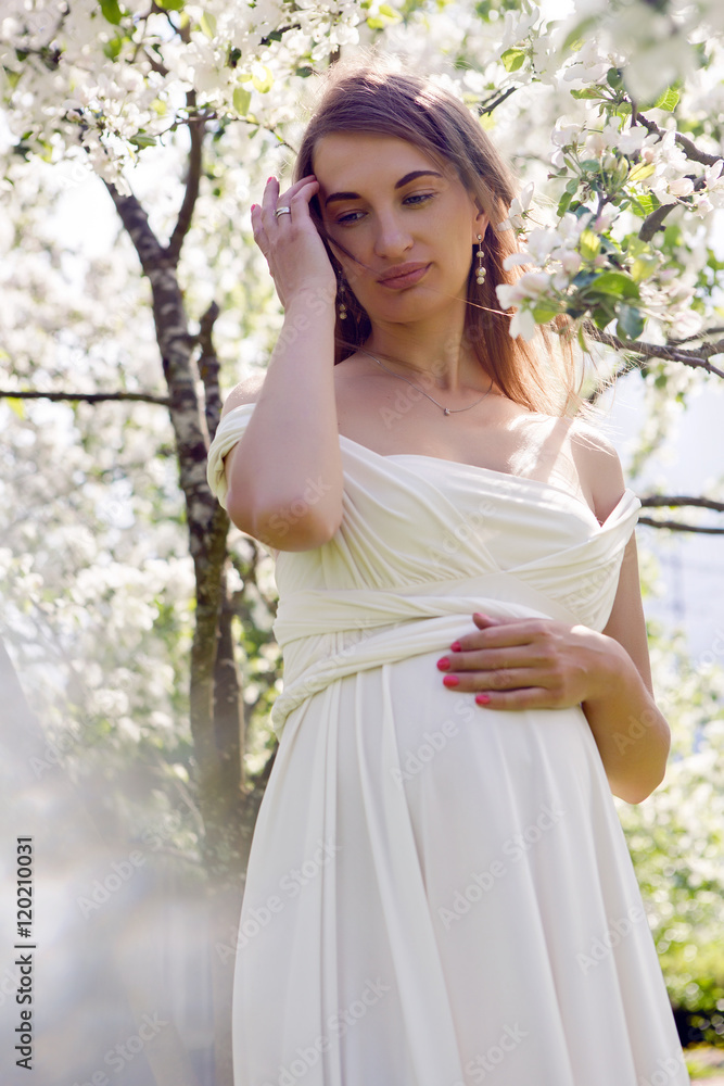 pregnant girl with long hair wearing a white dress standing pregnant girl with long hair wearing a white dress standing