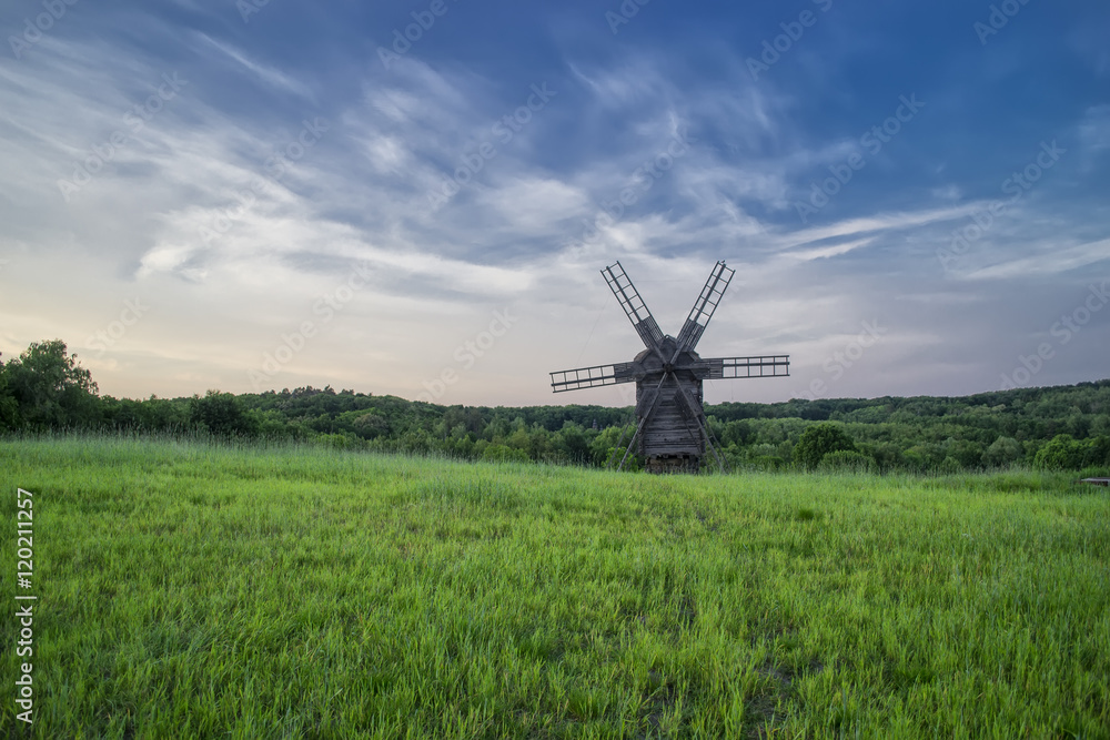 Windmills in the field under the clouds at sunset in the national museum of culture and life Pirogovo, Kiev, Ukraine, Europe Windmills in the field under the clouds at sunset in the national museum of culture and life Pirogovo, Kiev, Ukraine, Europe
