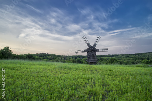Windmills in the field under the clouds at sunset in the national museum of culture and life Pirogovo, Kiev, Ukraine, Europe