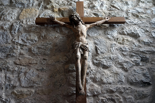 Foto Wooden crucifix on the stone wall