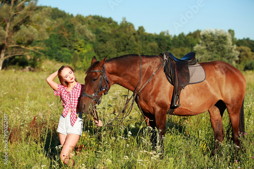 девушка блондинка с на прогулке с лошадью в поле