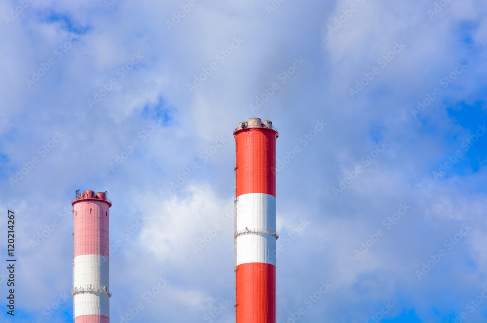 The chimneys against the blue sky with clouds