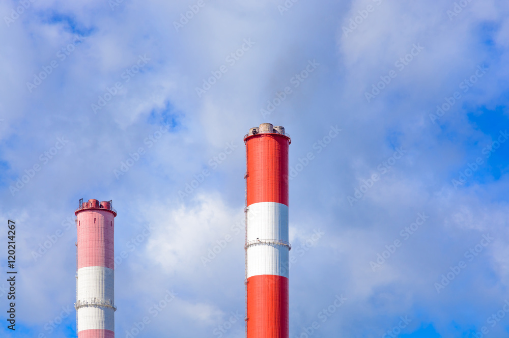 The chimneys against the blue sky with clouds The chimneys against the blue sky with clouds