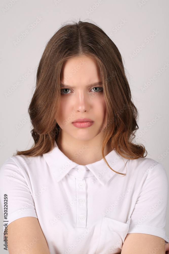 Girl with grimace in T-shirt. Close up. White background Girl with grimace in T-shirt. Close up. White background
